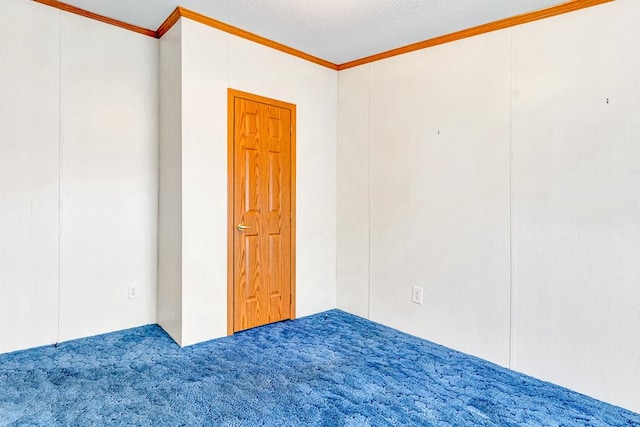 carpeted empty room featuring a textured ceiling and crown molding