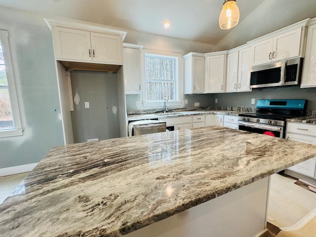 kitchen with stainless steel appliances, light stone countertops, lofted ceiling, and white cabinets