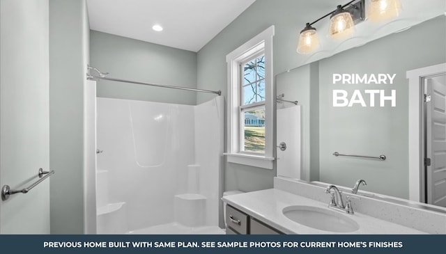 bathroom featuring walk in shower and vanity