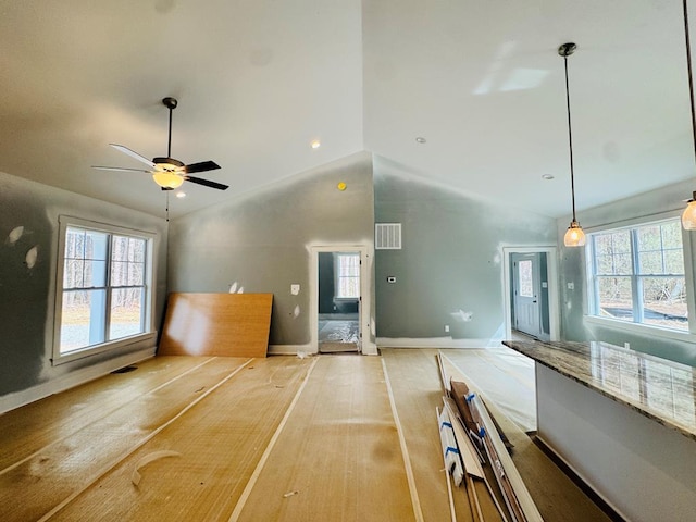 unfurnished living room with visible vents, baseboards, a healthy amount of sunlight, and ceiling fan