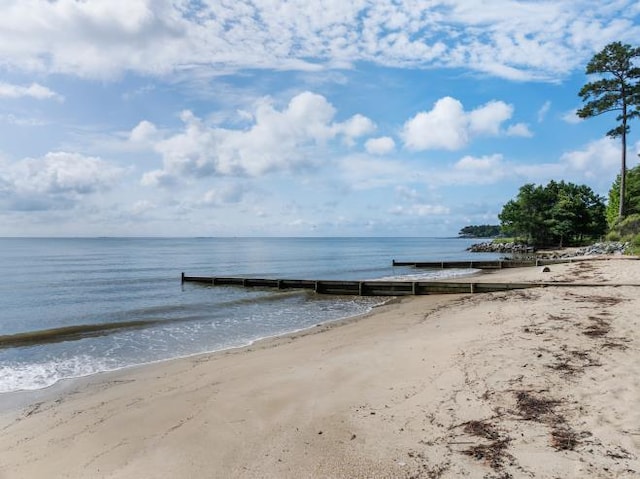 view of water feature featuring a dock and a beach view