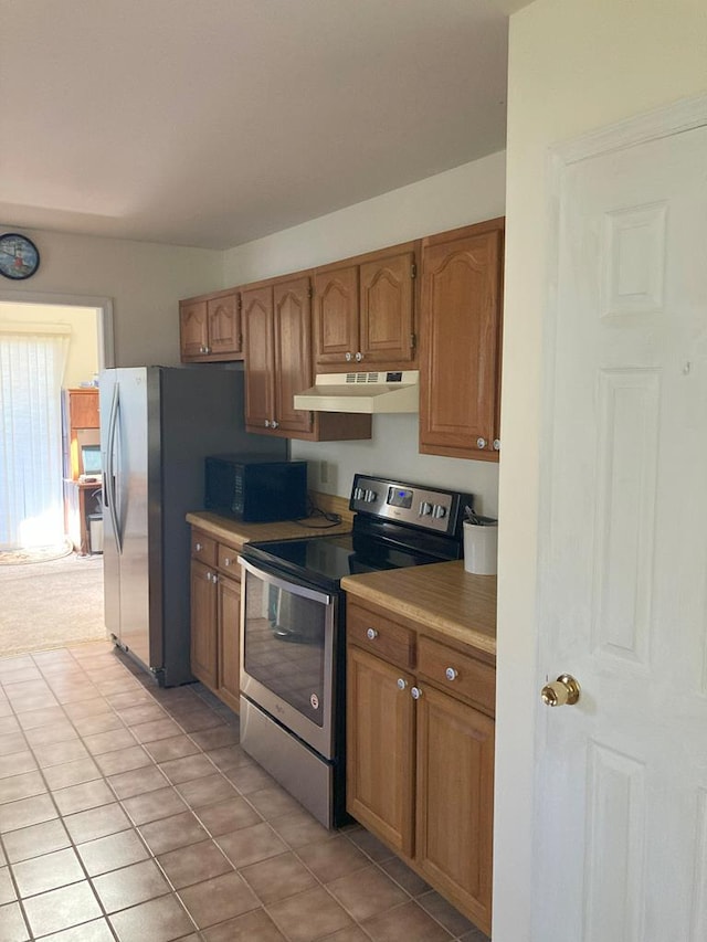 899 N Glebe Rd, Montross, VA 22520 - kitchen with stainless steel electric range, under cabinet range hood, black microwave, brown cabinetry, and light tile patterned floors