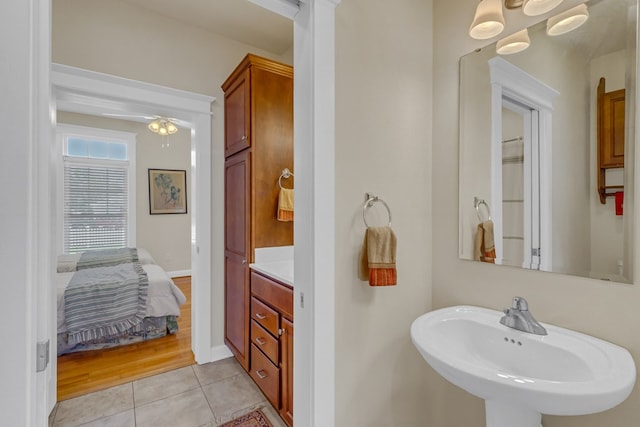 full bath featuring baseboards, tile patterned floors, a sink, a ceiling fan, and ensuite bathroom