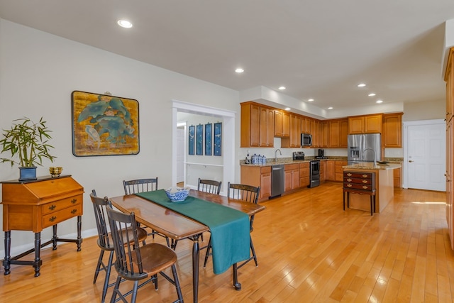 dining space featuring light wood-style flooring, baseboards, and recessed lighting