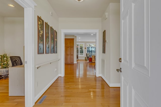hallway featuring baseboards, visible vents, recessed lighting, and light wood-type flooring