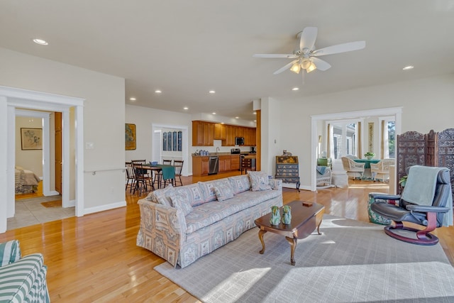 living room with baseboards, recessed lighting, and light wood-style floors