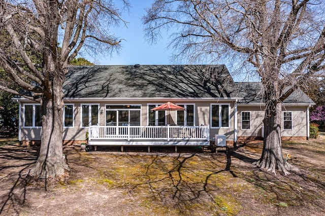 view of front of property with central AC, roof with shingles, and a deck
