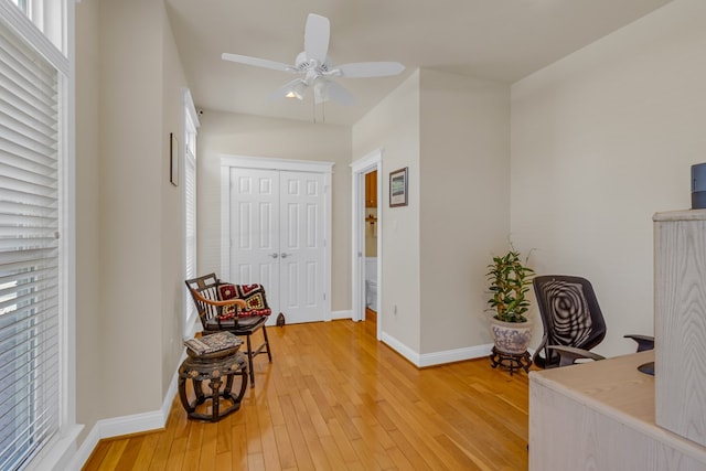 sitting room with a ceiling fan, plenty of natural light, baseboards, and light wood finished floors