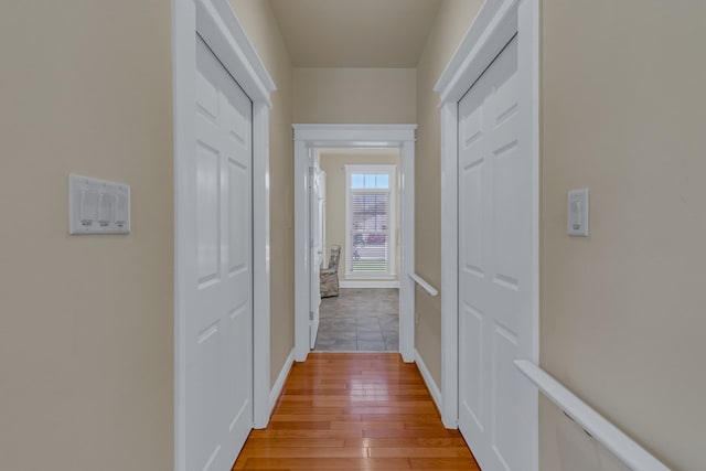 corridor featuring baseboards and light wood-style floors