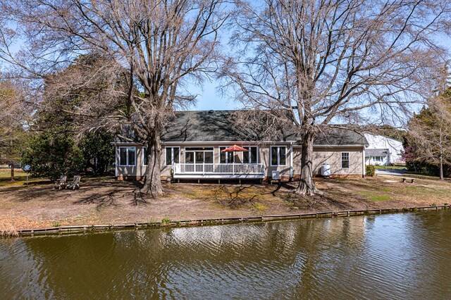 rear view of house featuring a deck with water view
