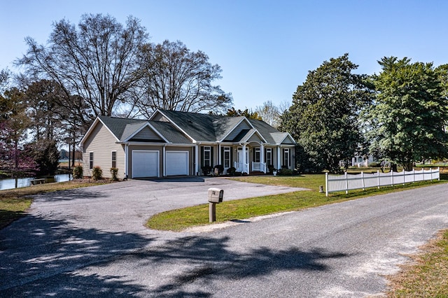 view of front of house with driveway, an attached garage, fence, and a front lawn