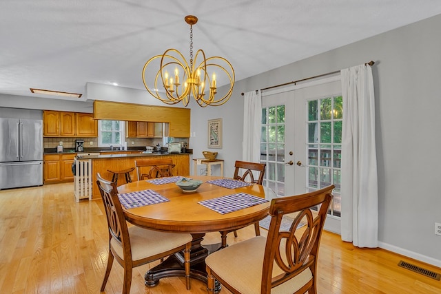 604 High Point Trl, Heathsville, VA 22473 - dining area with french doors, light wood finished floors, and a chandelier