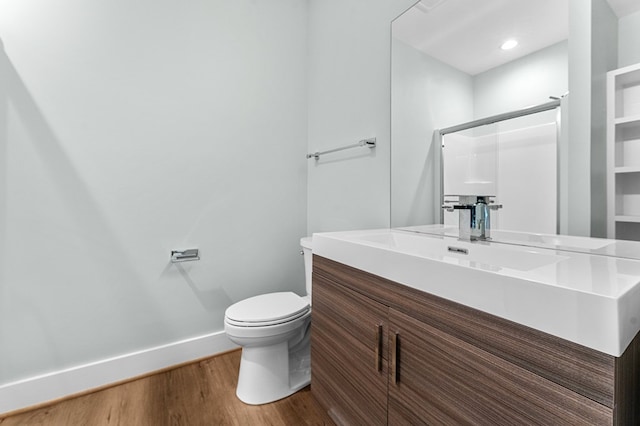 bathroom with vanity, hardwood / wood-style flooring, toilet, and a shower with shower door