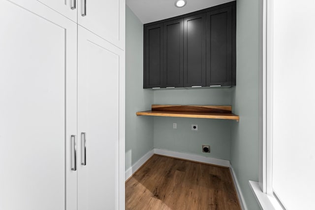 laundry area with hardwood / wood-style floors, electric dryer hookup, and cabinets