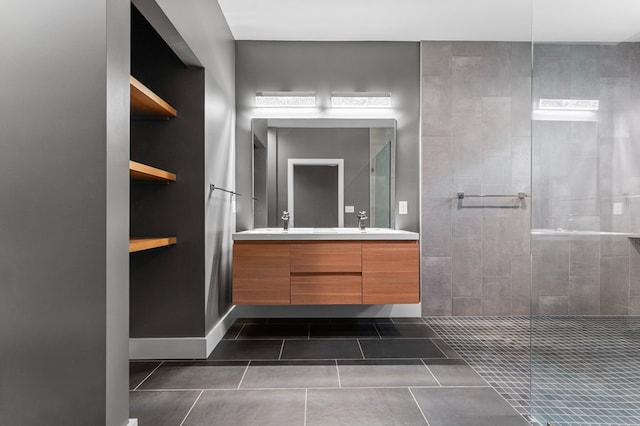 bathroom with tile patterned flooring, vanity, and tiled shower