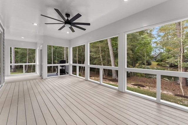 unfurnished sunroom featuring ceiling fan and a healthy amount of sunlight