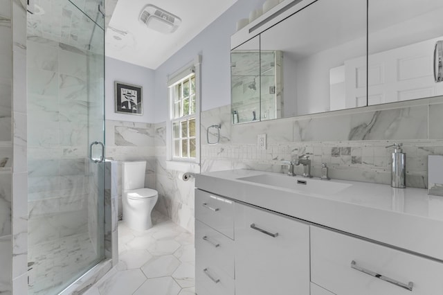 bathroom with vanity, toilet, tile walls, and a shower with shower door