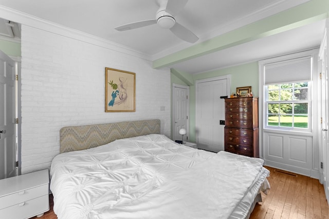 bedroom with ceiling fan, a closet, brick wall, and light hardwood / wood-style flooring