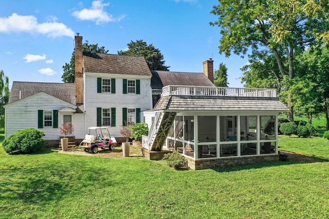 back of property featuring a lawn and a sunroom