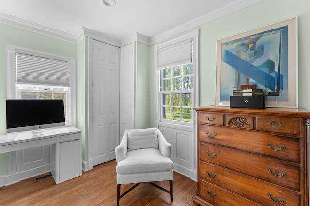 sitting room with light wood-type flooring and ornamental molding