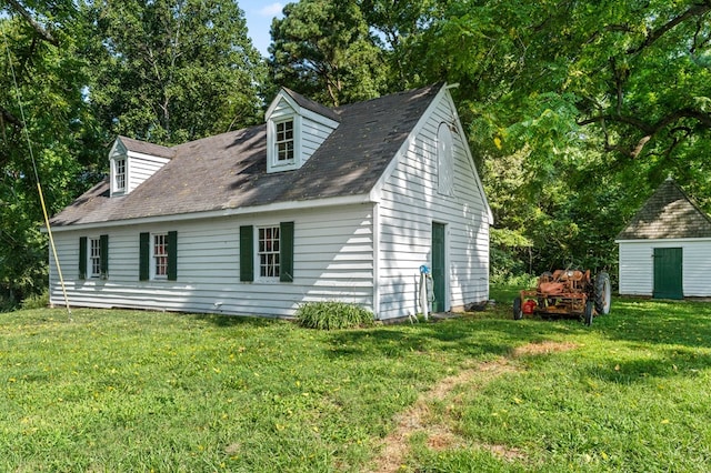 rear view of property featuring a yard and a shed