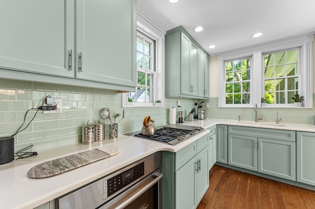 kitchen with tasteful backsplash, a wealth of natural light, sink, and dark hardwood / wood-style floors