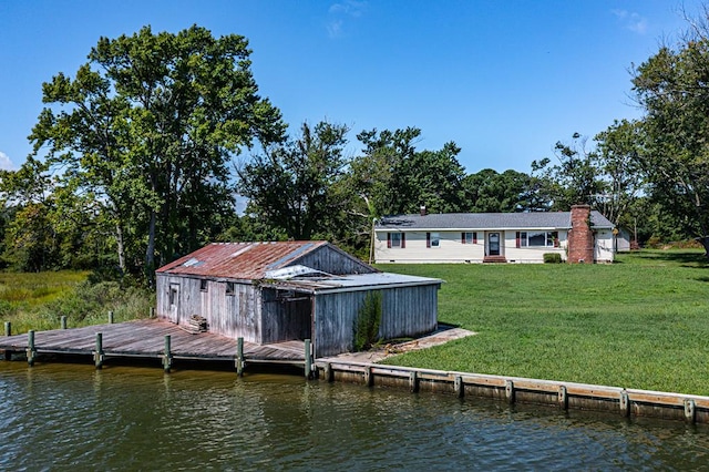 rear view of property with a lawn and a water view