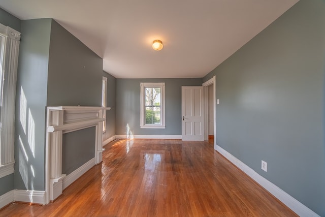 unfurnished living room with baseboards and wood finished floors
