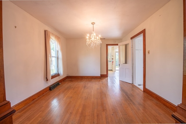 unfurnished dining area featuring visible vents, baseboards, a chandelier, and light wood-type flooring