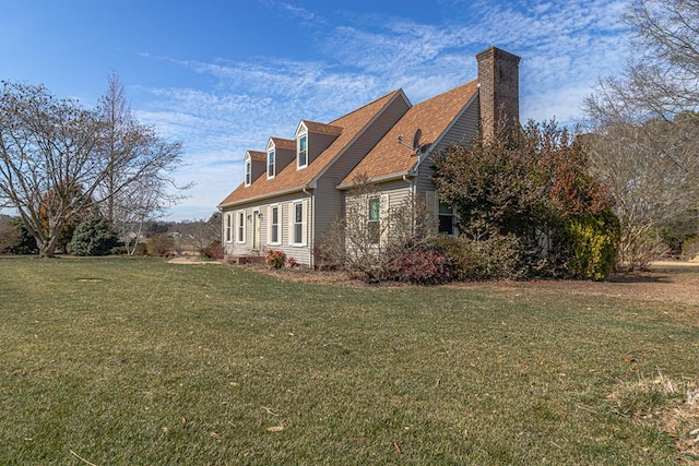 view of side of property featuring a lawn and a chimney