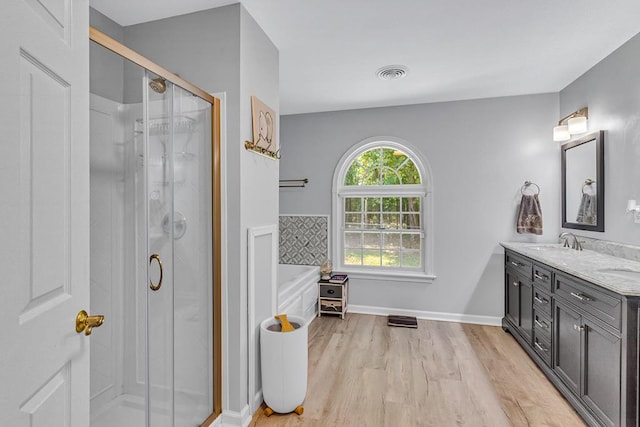 889 Taylors Creek Rd, Weems, VA 22576 - bathroom featuring double vanity, a shower stall, a bath, and wood finished floors