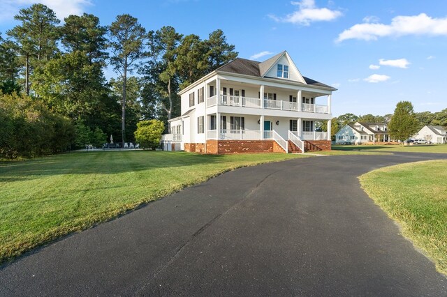 480 Rockingham Rd, Dunnsville, VA 22454 - view of front of house featuring a front lawn, covered porch, and a balcony