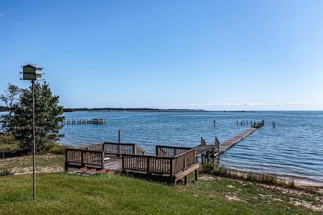 dock area featuring a water view and a lawn