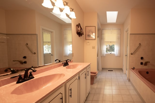 bathroom with tile patterned floors, vanity, a skylight, and toilet