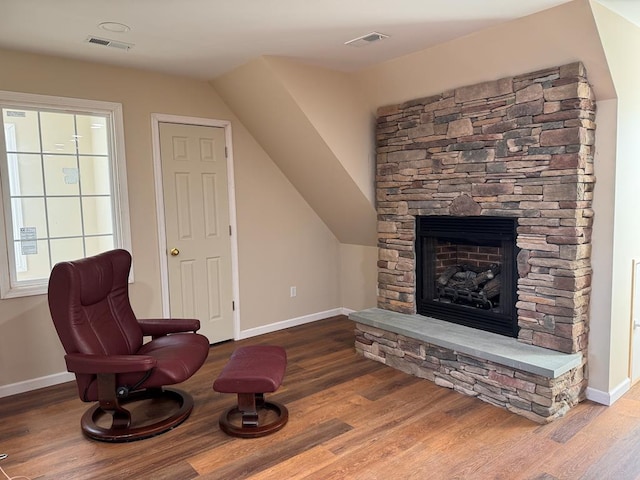 living area with hardwood / wood-style flooring and a fireplace