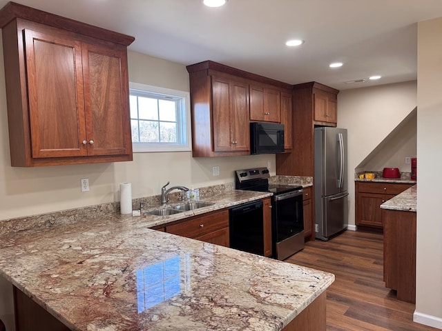 kitchen featuring sink, dark wood-type flooring, light stone counters, black appliances, and kitchen peninsula