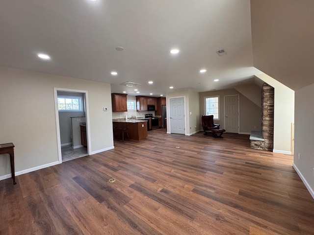 unfurnished living room with a healthy amount of sunlight and dark hardwood / wood-style flooring