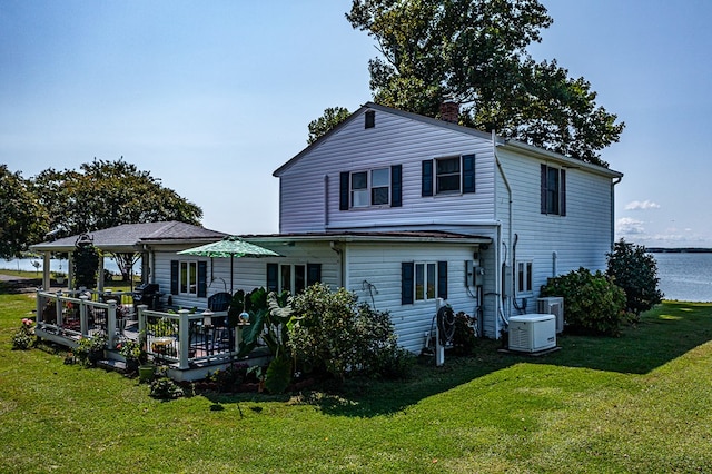 rear view of house featuring a lawn, central air condition unit, and a deck with water view