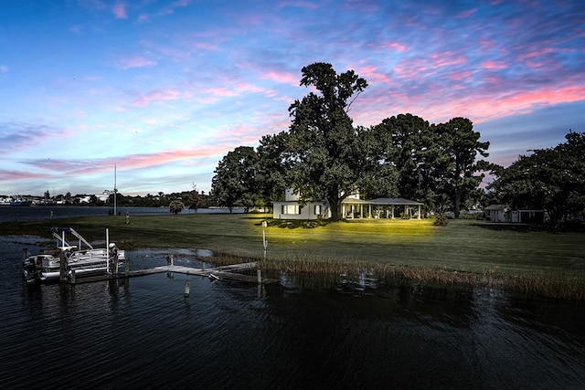 dock area with a water view and a yard