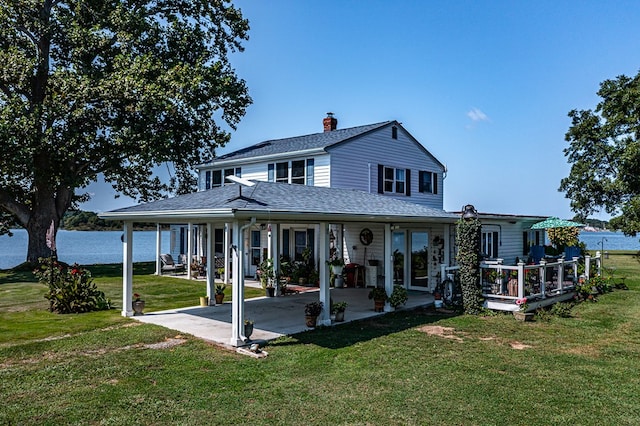 view of front facade with a front yard, a water view, and a patio area