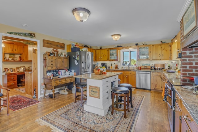 kitchen with stainless steel appliances, tasteful backsplash, light hardwood / wood-style flooring, a breakfast bar area, and a kitchen island