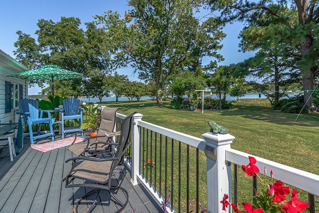 wooden terrace featuring a water view and a yard