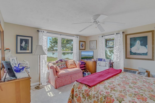 carpeted bedroom with ceiling fan and a textured ceiling