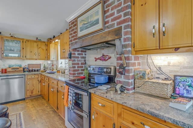 kitchen with light stone countertops, decorative backsplash, stainless steel appliances, light hardwood / wood-style flooring, and range hood