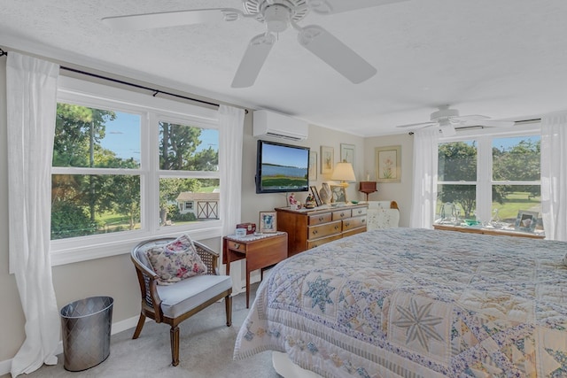 carpeted bedroom featuring a wall unit AC, multiple windows, ceiling fan, and a textured ceiling