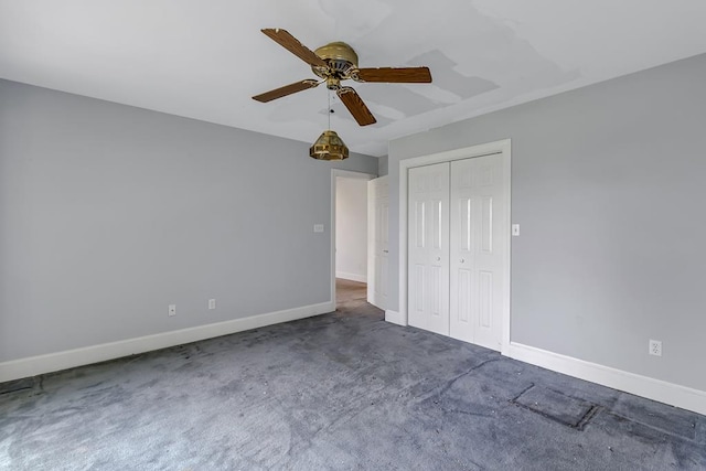 unfurnished bedroom with ceiling fan, a closet, and dark carpet