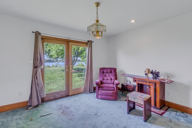 sitting room featuring carpet floors, french doors, and an inviting chandelier