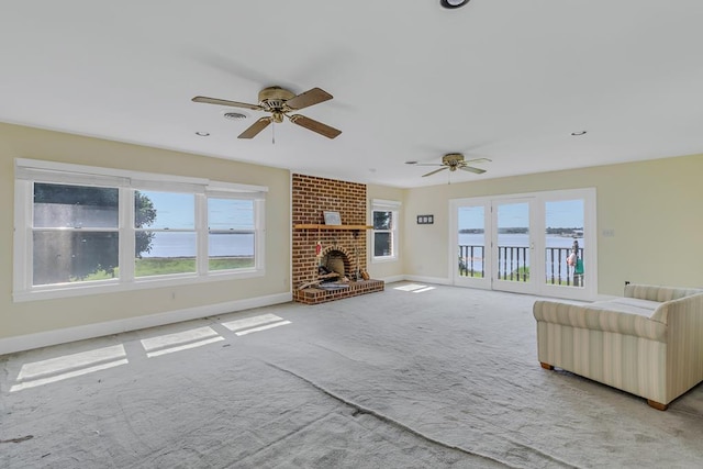 unfurnished living room with light carpet, a brick fireplace, and ceiling fan