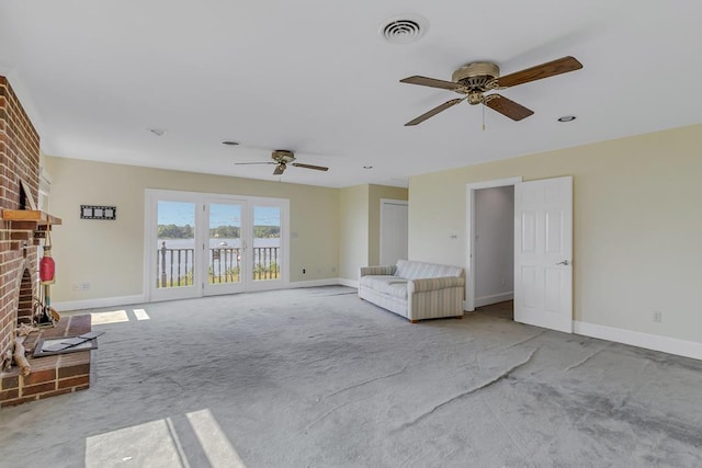 unfurnished living room with ceiling fan, a fireplace, and light carpet