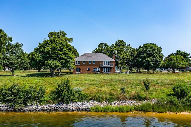 back of house featuring a water view and a balcony